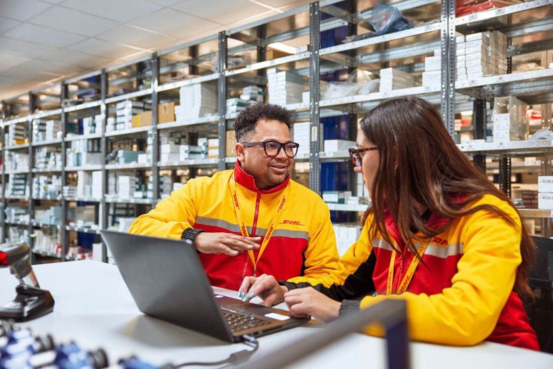 Image of two DHL employees dicussing.